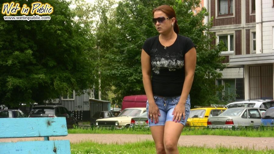 Mädchen mit Sonnenbrille hält ihre absolut pinkelnden Shorts zur Ansicht hoch
 #73240704