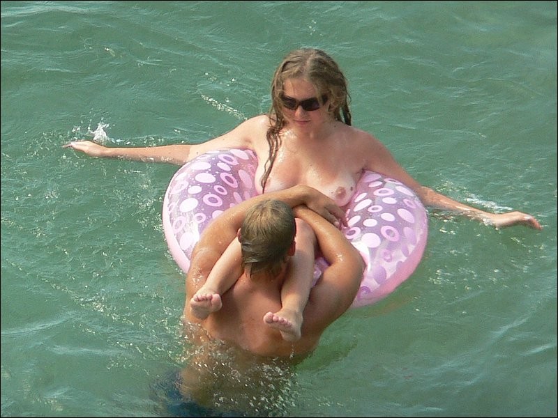 Una chica desnuda se lo pasa en grande bajo el sol de la playa
 #72259527