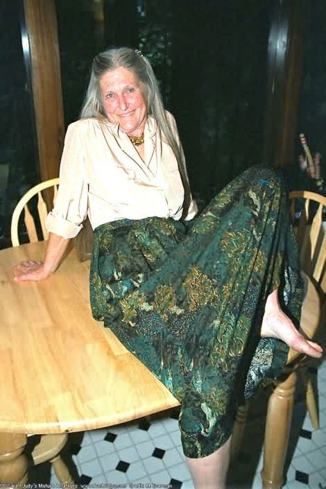 Une mamie hippie de plus de 60 ans, aux cheveux gris, se déshabille et s'épanche.
 #77250351
