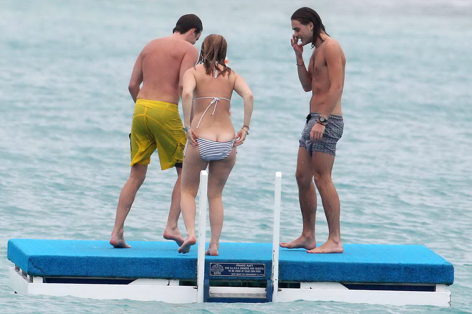 Alice eve en train de se glisser hors de son bikini à rayures sur une plage de la Barbade. #75208950