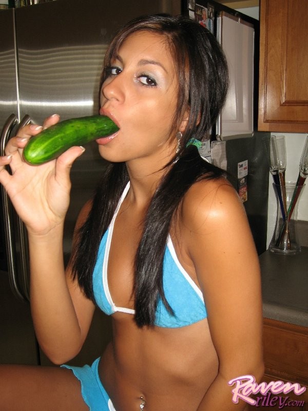 Morena raven juega con un pepino
 #70623167