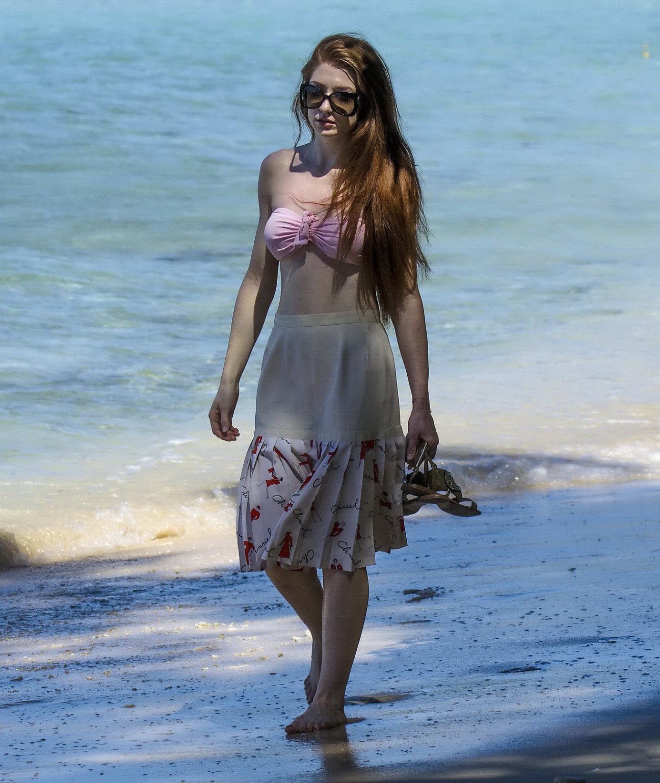 ビーチでピンクのビキニトップを着たニコラ・ロバーツの胸元
 #75146784