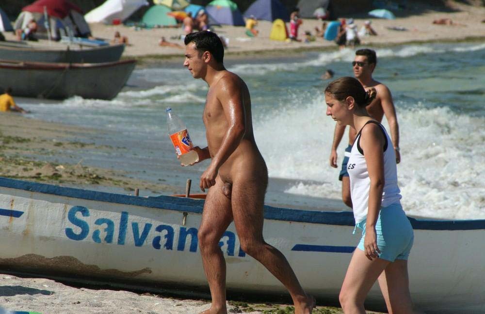 Amigos jóvenes nudistas retozan en una playa nudista
 #72255752