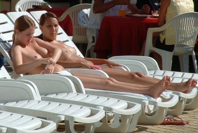 Una ragazza nuda e selvaggia si diverte in una spiaggia nudista
 #72253631