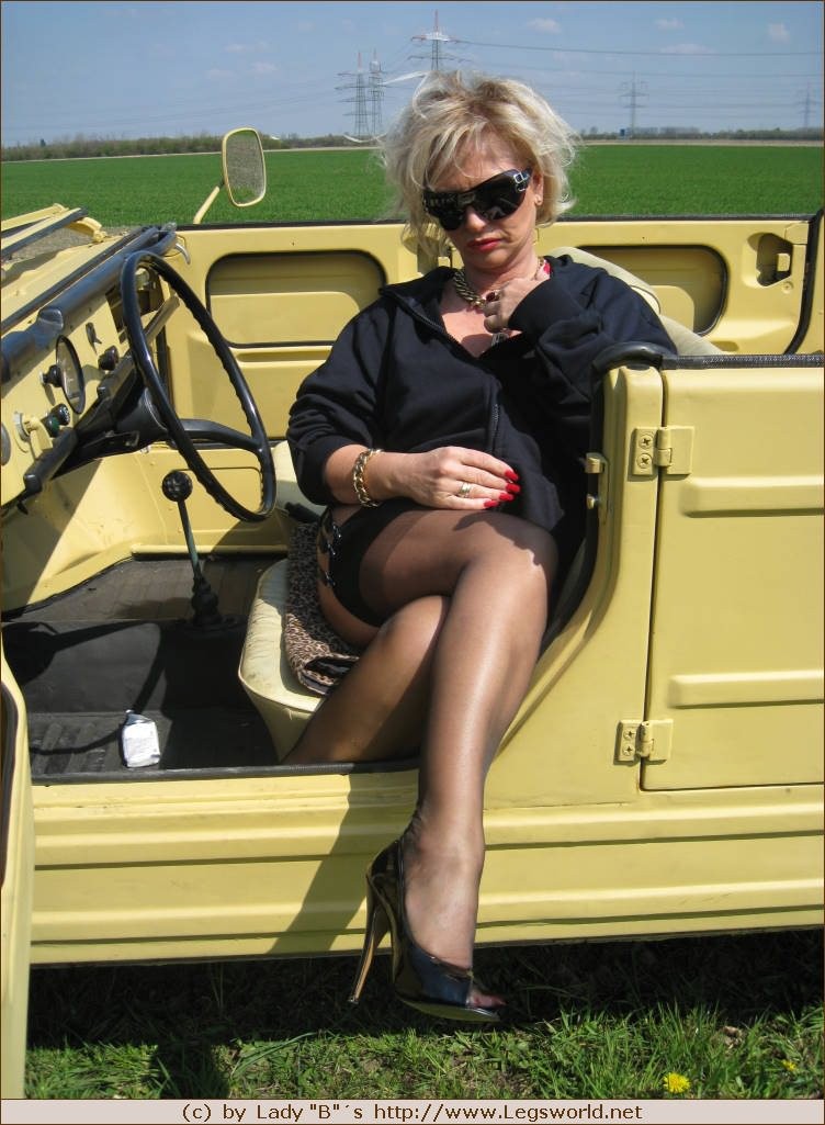 Barbara en bas de nylon posant dans sa voiture jaune
 #76476343