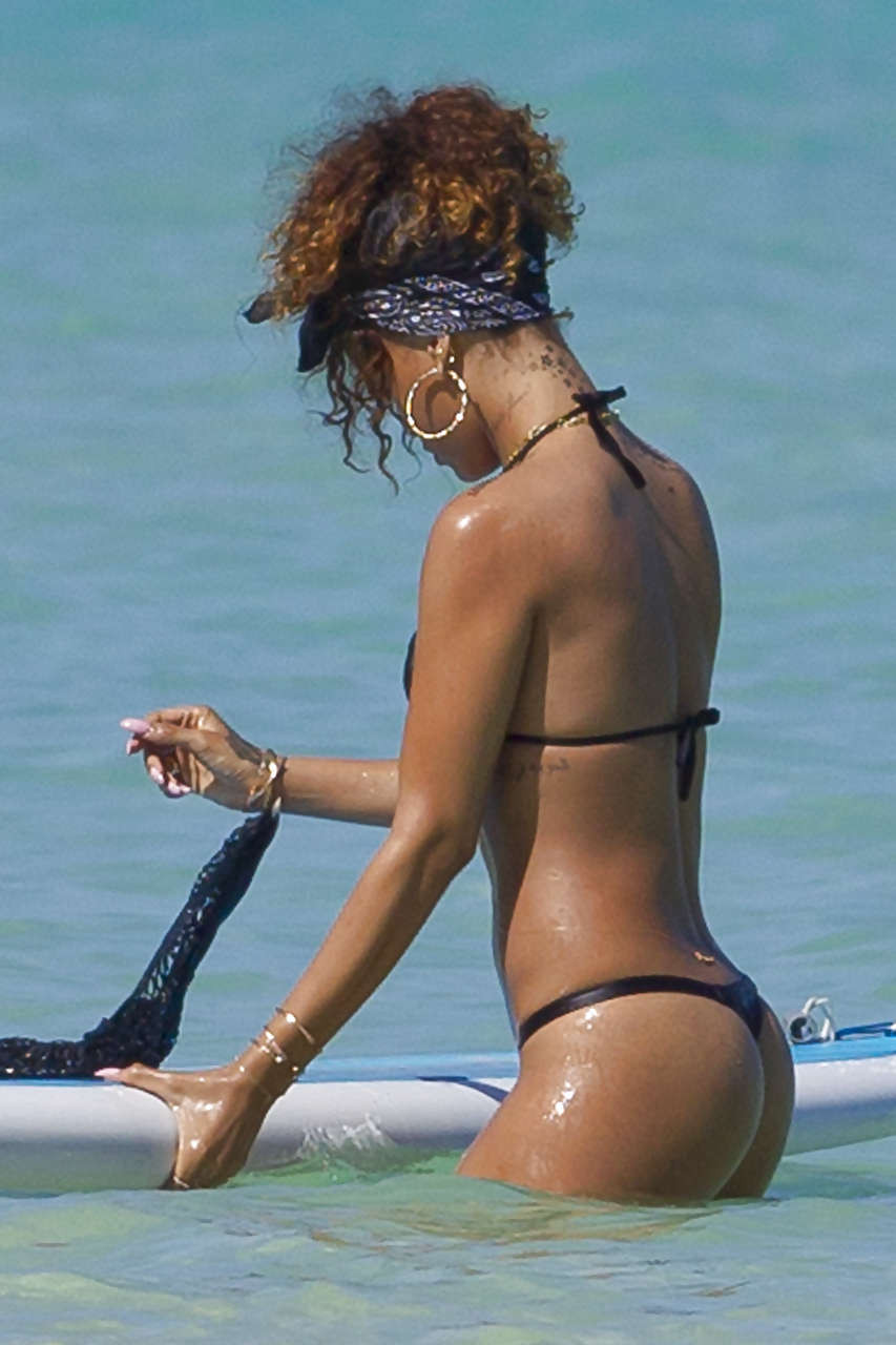 Rihanna showing her great ass in black thong on beach paparazzi photos #75275614