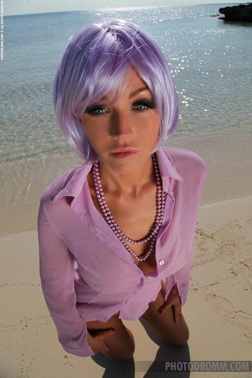 イギリスのグラマーモデル、ホリー・ヘンダーソンがビーチで紫のかつらをかぶっている。
 #71065285
