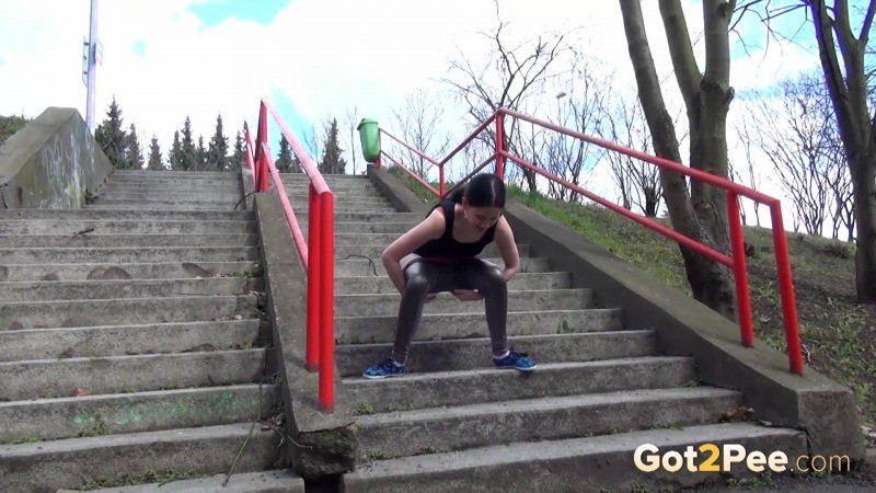 Chica de pelo oscuro orina en los escalones de hormigón
 #67499712