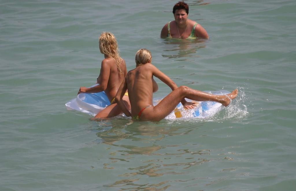 Une jeune nudiste à peine majeure s'allonge nue sur la plage.
 #72248827