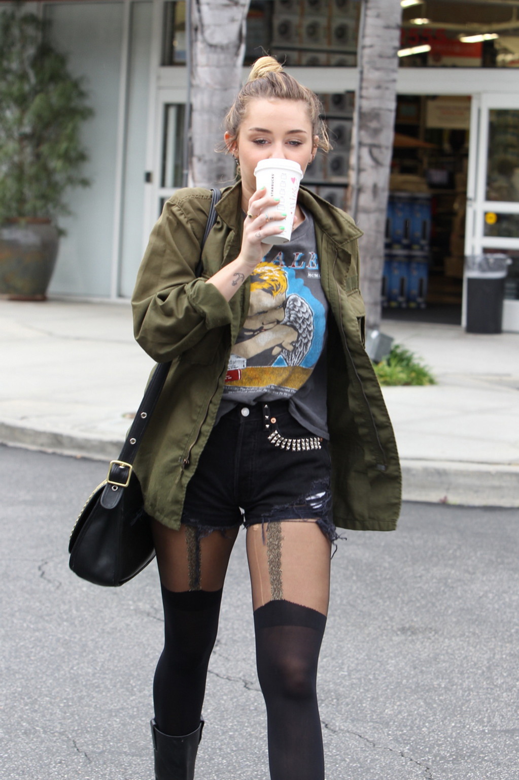 Miley Cyrus portant des bas et des bottes de motard devant un café à Hollywood
 #75274241