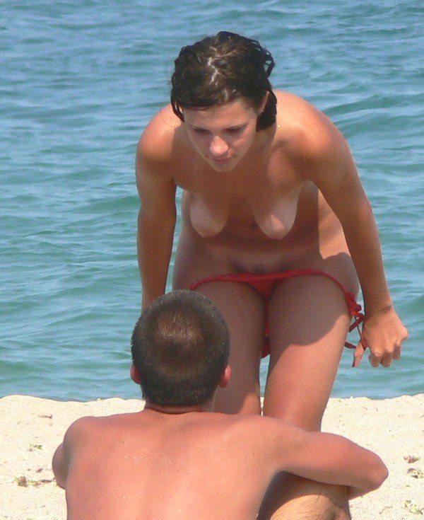 Giovani amici nudisti nudi insieme in spiaggia
 #72257367