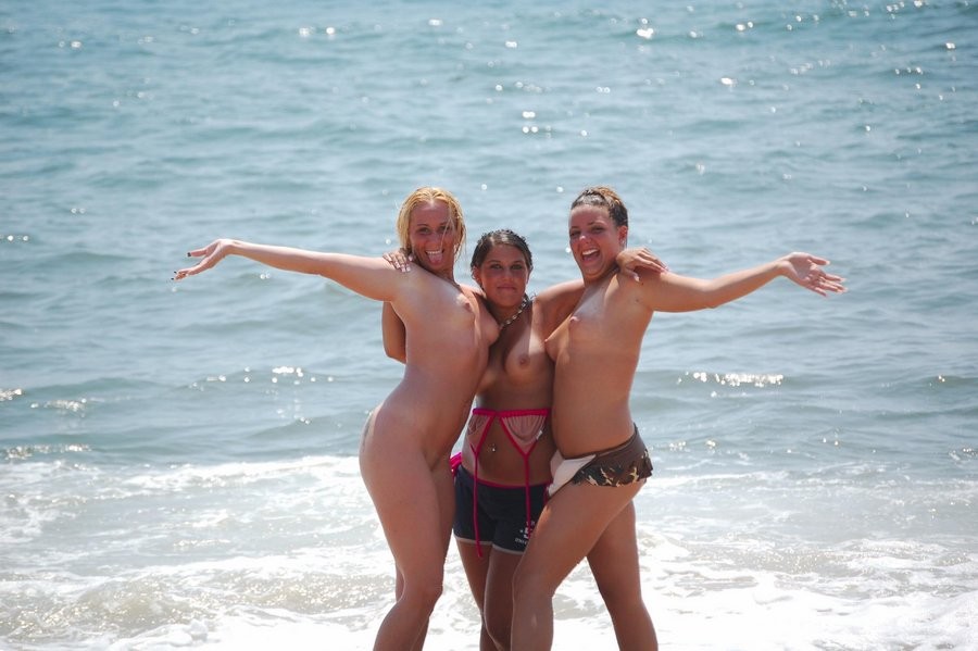 Giovani amici nudisti nudi insieme in spiaggia
 #72257391