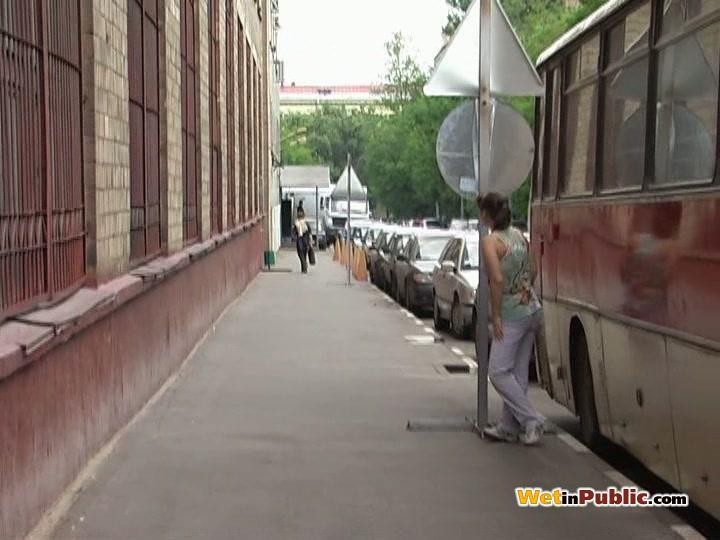 Une nana mouille son pantalon blanc derrière un bus car elle a une envie désespérée de faire pipi.
 #78595257