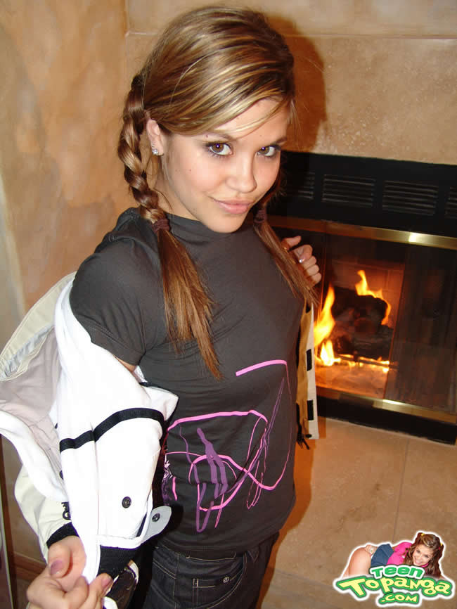 Brunette teen with braces posing by the fireplace #74945963
