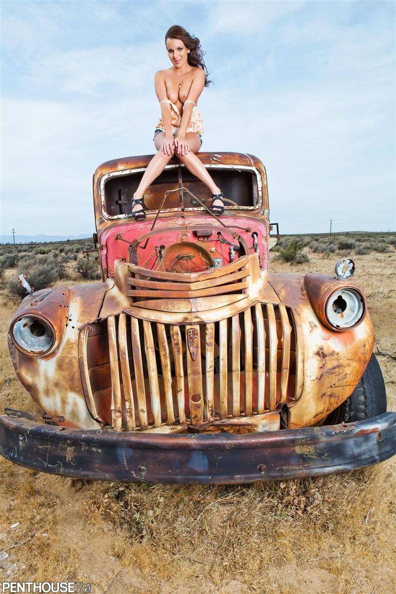 Jenna rose posa sobre una vieja camioneta oxidada
 #74754334