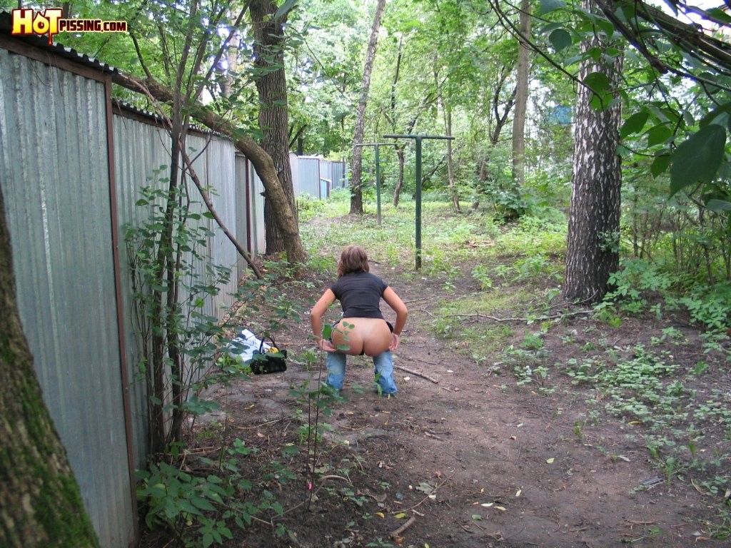 Spy camera shots of a gal in jeans as she does a leak behind a garage #76565087