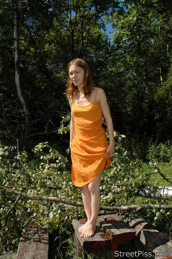 Young hottie in bright dress pees on forest wood #76562615