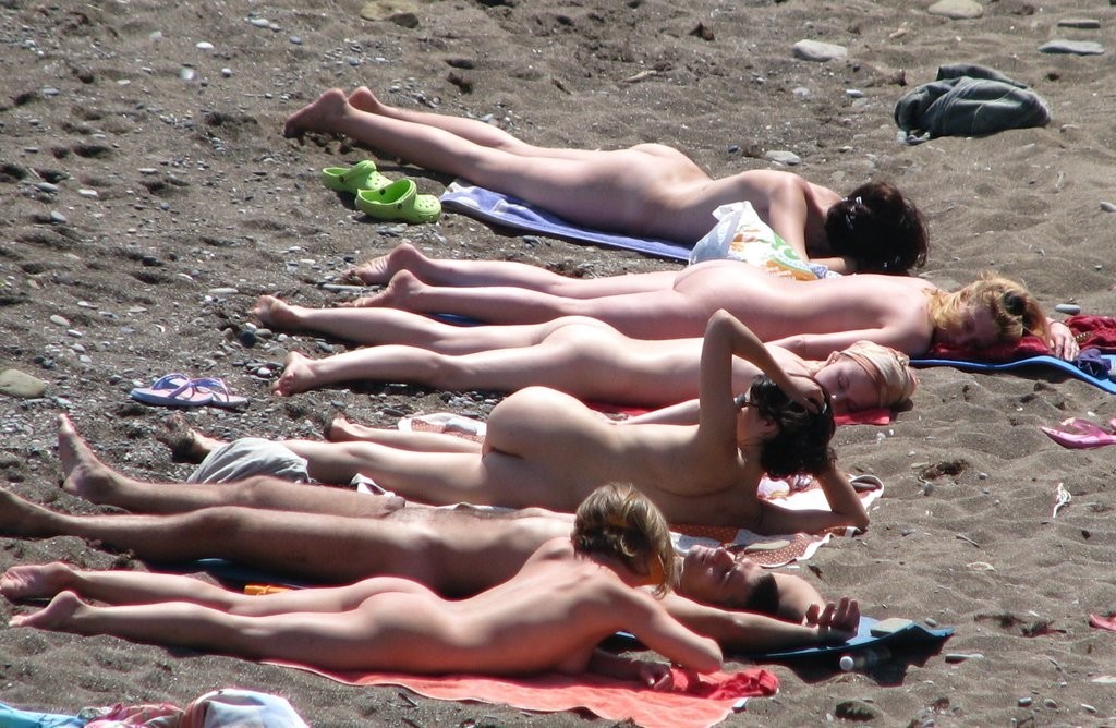 Des filles nudistes s'allongent au soleil, totalement exposées.
 #72242418