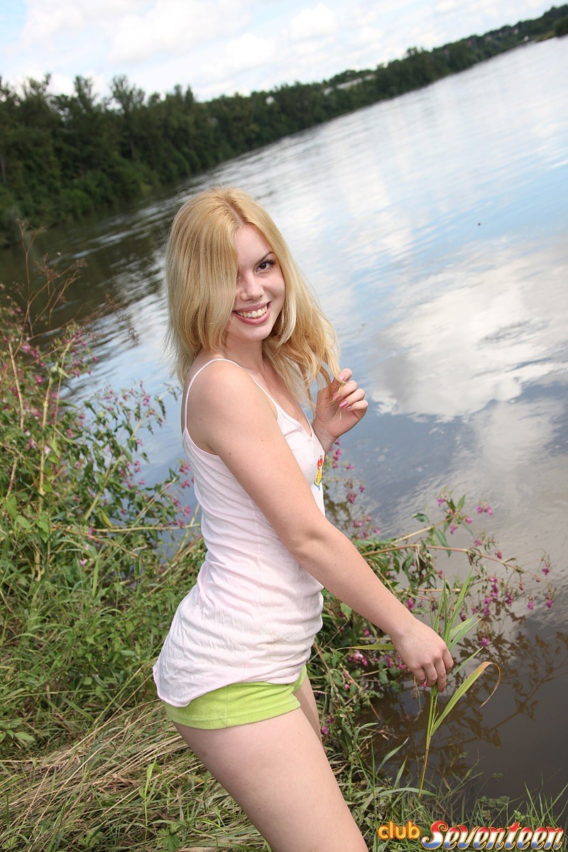 Une jeune nue et excitée se masturbe près d'un lac en utilisant un jouet
 #76194418
