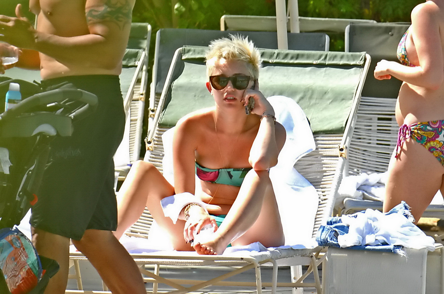 Miley Cyrus trägt einen geblümten Röhrenbikini am Pool des Palm Desert Hotels in Palm Spr
 #75238590
