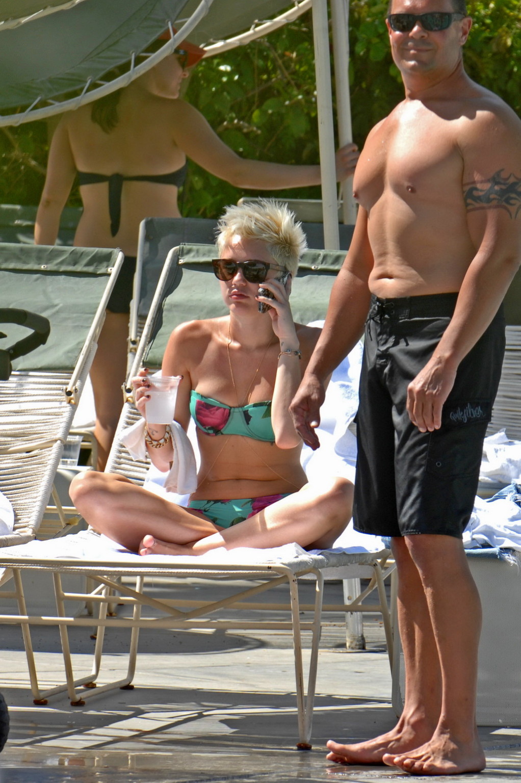 Miley cyrus luciendo un bikini de tubo floral junto a la piscina en el hotel palm desert en palm spr
 #75238646