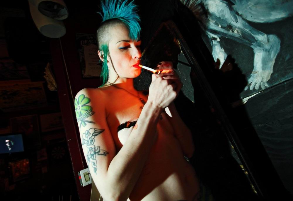 Nena punk tatuada y con piercing posando y chupando
 #73227151