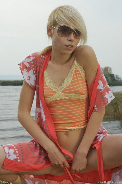 Adorable jeune blonde aux petits seins posant nue sur la plage
 #72840435