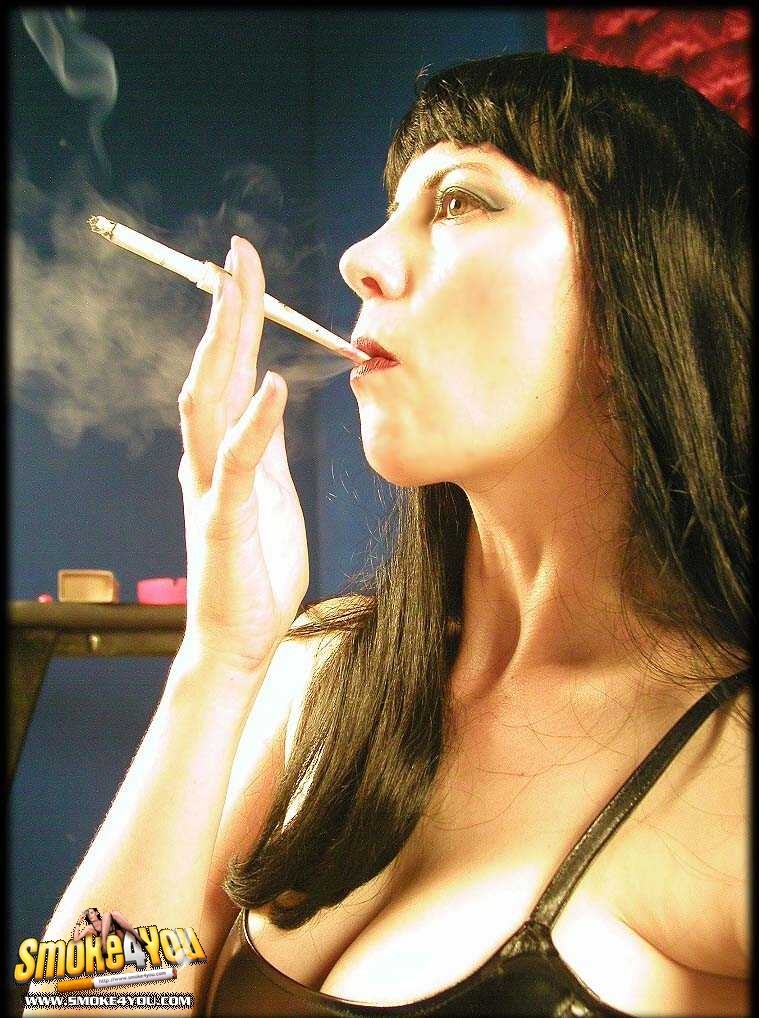 Zorra en minivestido negro se pinta los labios con el cigarrillo
 #76571810