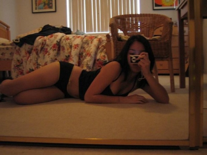 Une jeune asiatique entièrement nue dans un canapé montre ses seins.
 #69874665