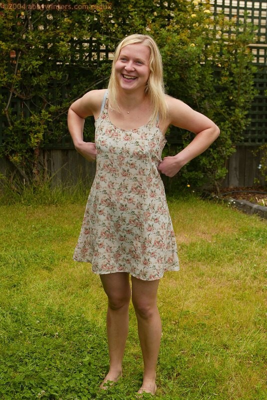 Long haired blonde shows her bare overall body in the backyard