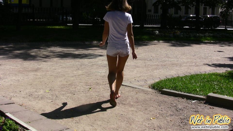 Une estivante en short blanc et tee-shirt coquin se fait pisser dessus en plein air.
 #73243819