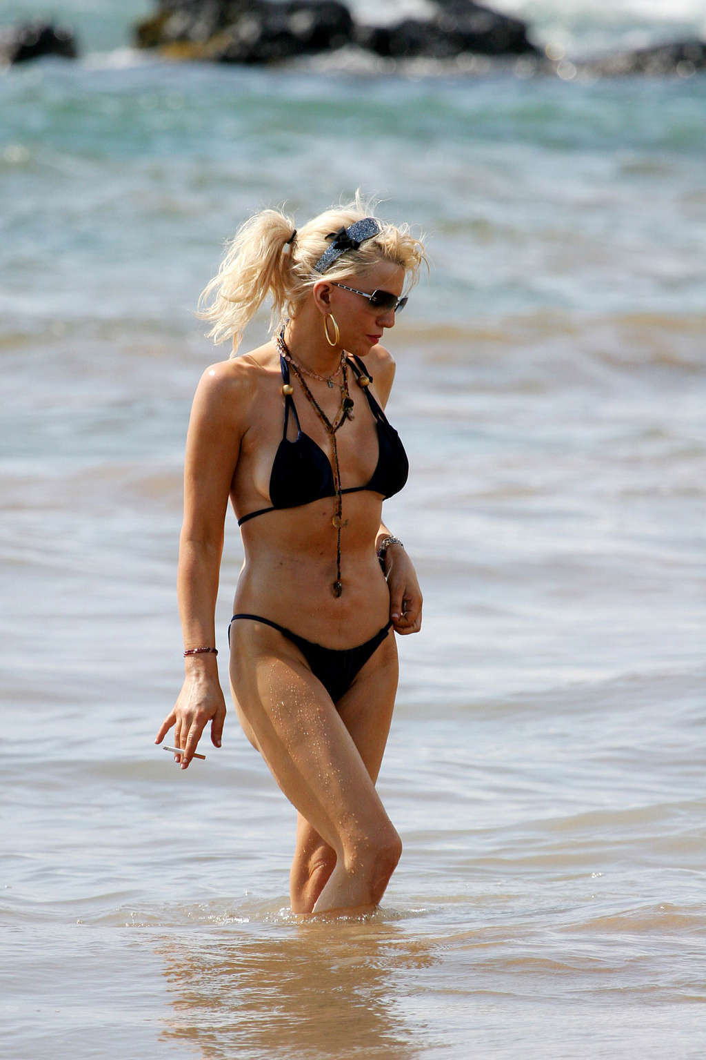 Courtney Love posing on the beach in black bikini and showing sexy body