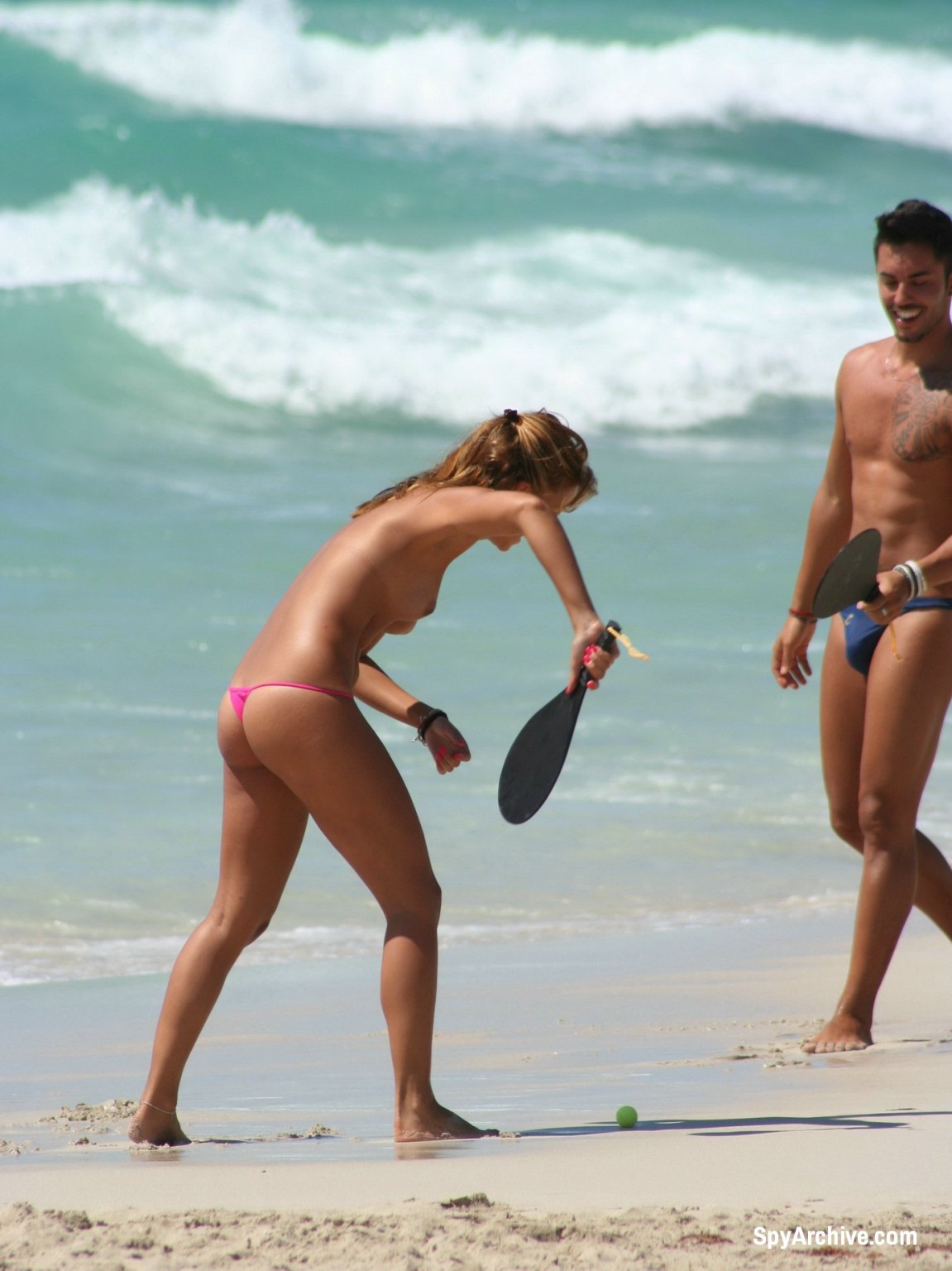 Photos voyeur d'une jolie fille aux seins nus jouant à la plage
 #72241953
