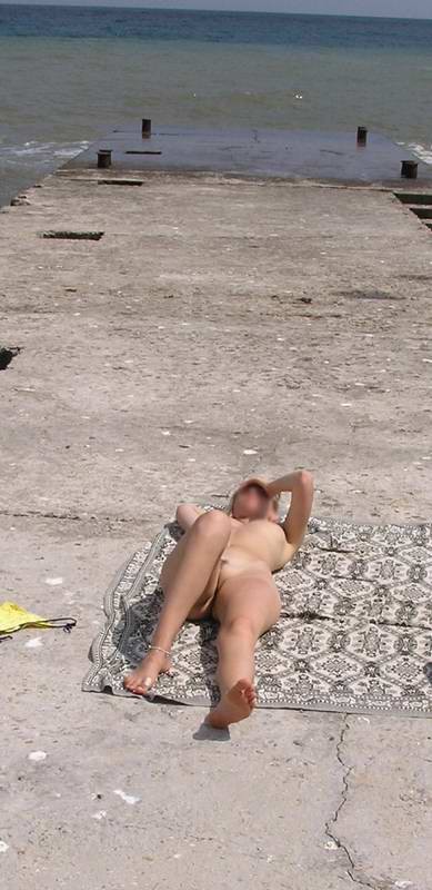 Blonde nudist strips down naked at a public beach #72250674