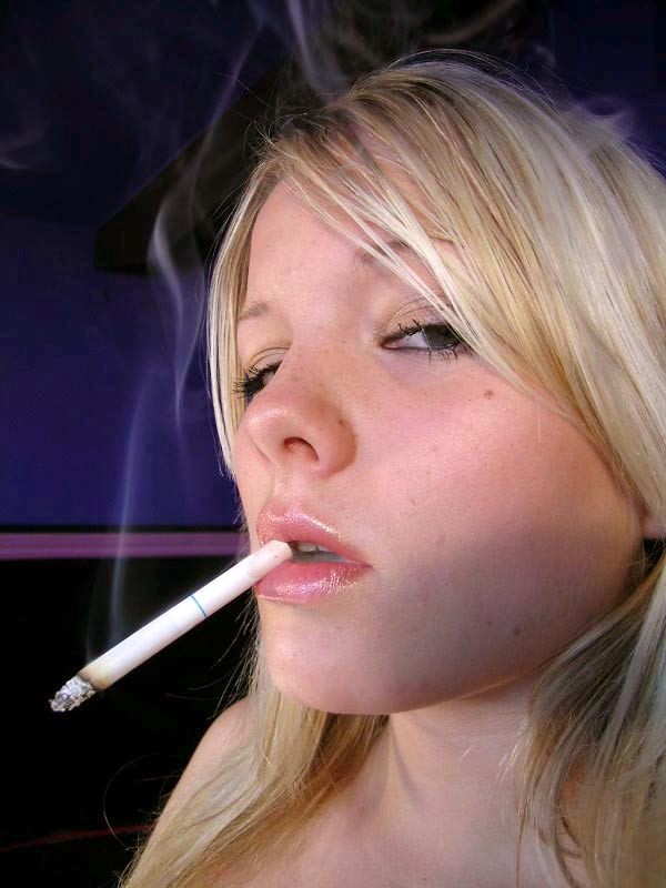 Jeune blonde sexy avec de beaux gros seins s'allume une cigarette
 #72776163