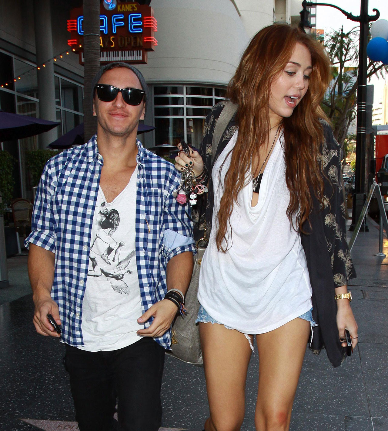 Miley Cyrus zeigt sexy Beine auf der Straße, während sie mit einem Freund spazieren geht
 #75353729
