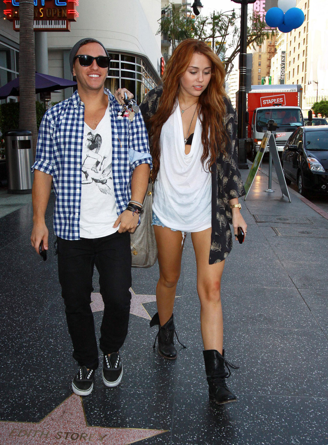 Miley Cyrus zeigt sexy Beine auf der Straße, während sie mit einem Freund spazieren geht
 #75353779
