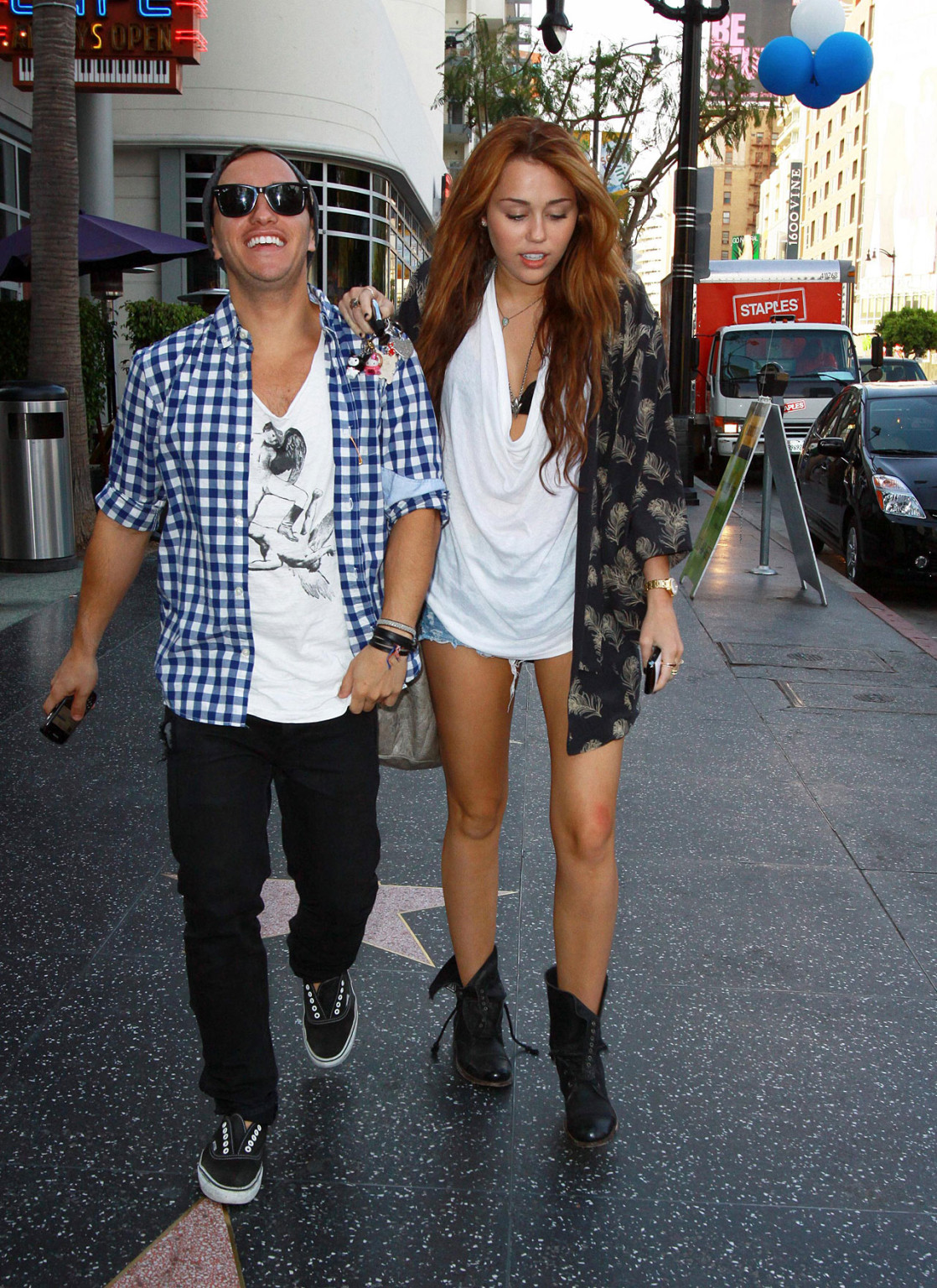 Miley Cyrus zeigt sexy Beine auf der Straße, während sie mit einem Freund spazieren geht
 #75353803