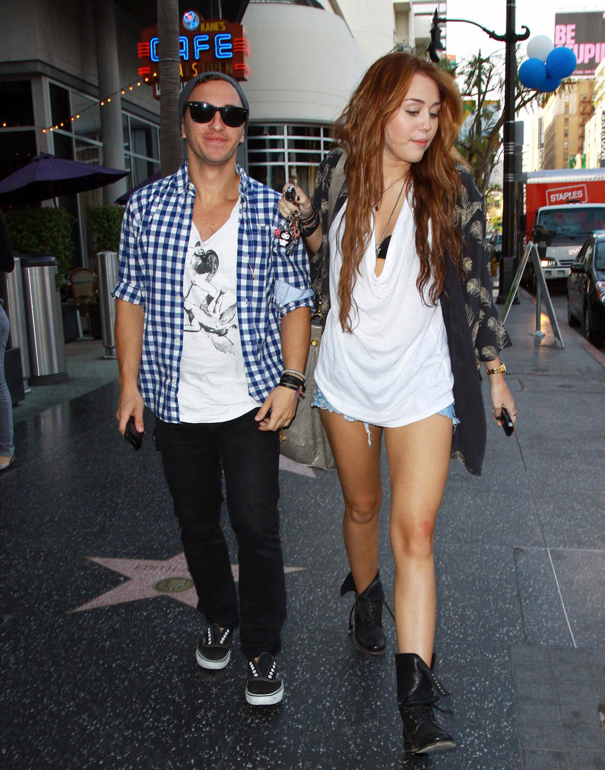 Miley Cyrus zeigt sexy Beine auf der Straße, während sie mit einem Freund spazieren geht
 #75353820