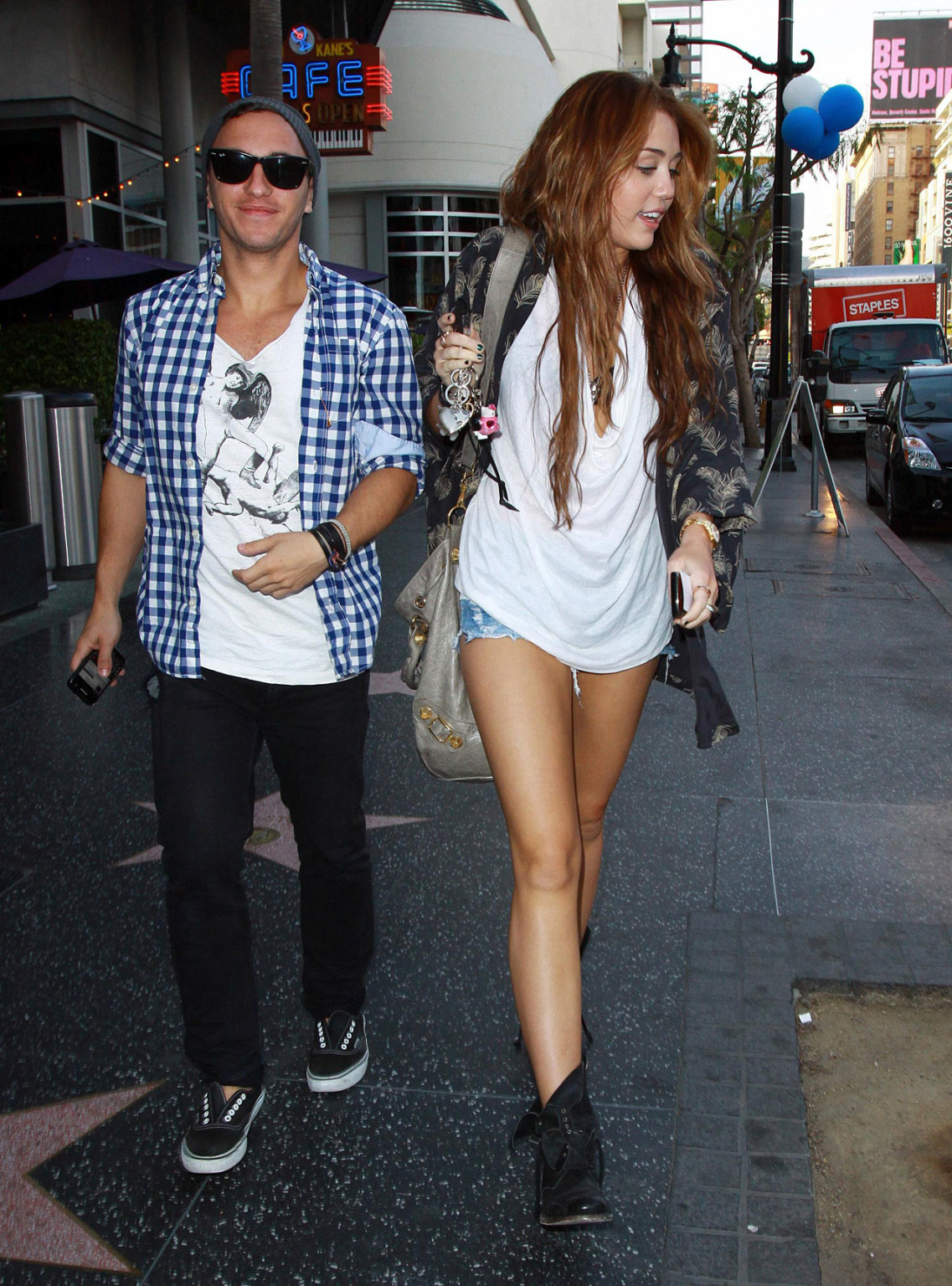 Miley Cyrus zeigt sexy Beine auf der Straße, während sie mit einem Freund spazieren geht
 #75353832