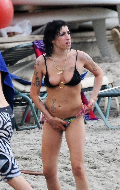 Amy winehouse jouant avec ses seins nus sur la plage
 #75376504