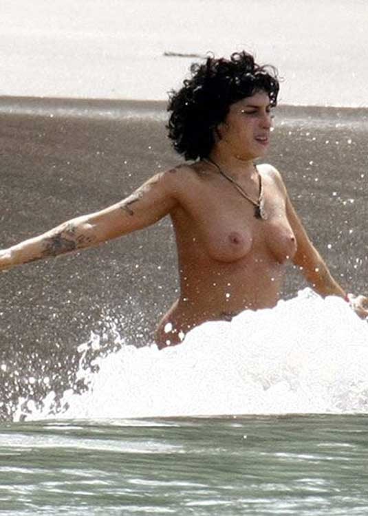 Amy winehouse jouant avec ses seins nus sur la plage
 #75376515