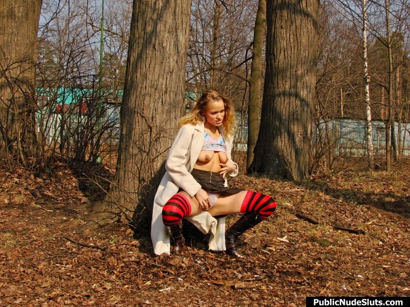 Une jeune fille surexcitée joue avec ses seins et se chatouille la chatte dans un parc.
 #76742033