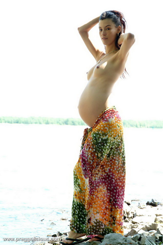 Belleza embarazada posando con su vientre redondo al aire libre
 #74899552