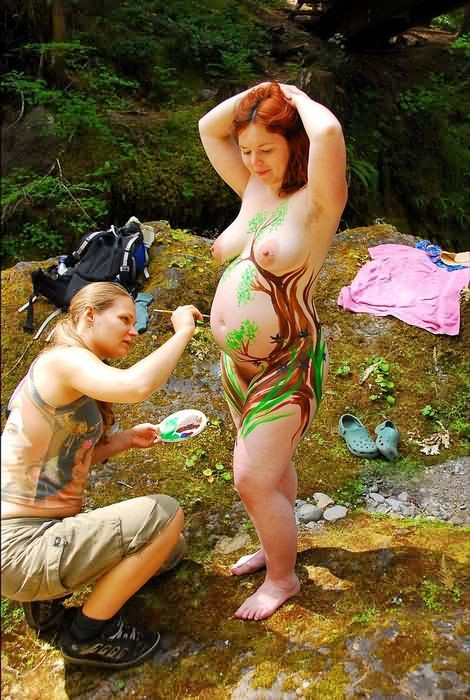 Nudiste enceinte, ventre rond, corps peint en plein air dans la forêt
 #75563165
