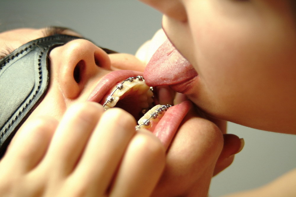Dominatrice con un dildo gioca con un giovane con il codino e l'apparecchio per i denti
 #76275503