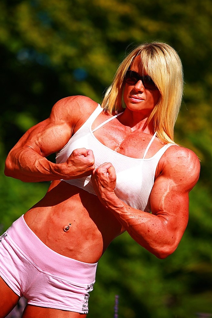 Massive ripped muscular woman posing outdoors