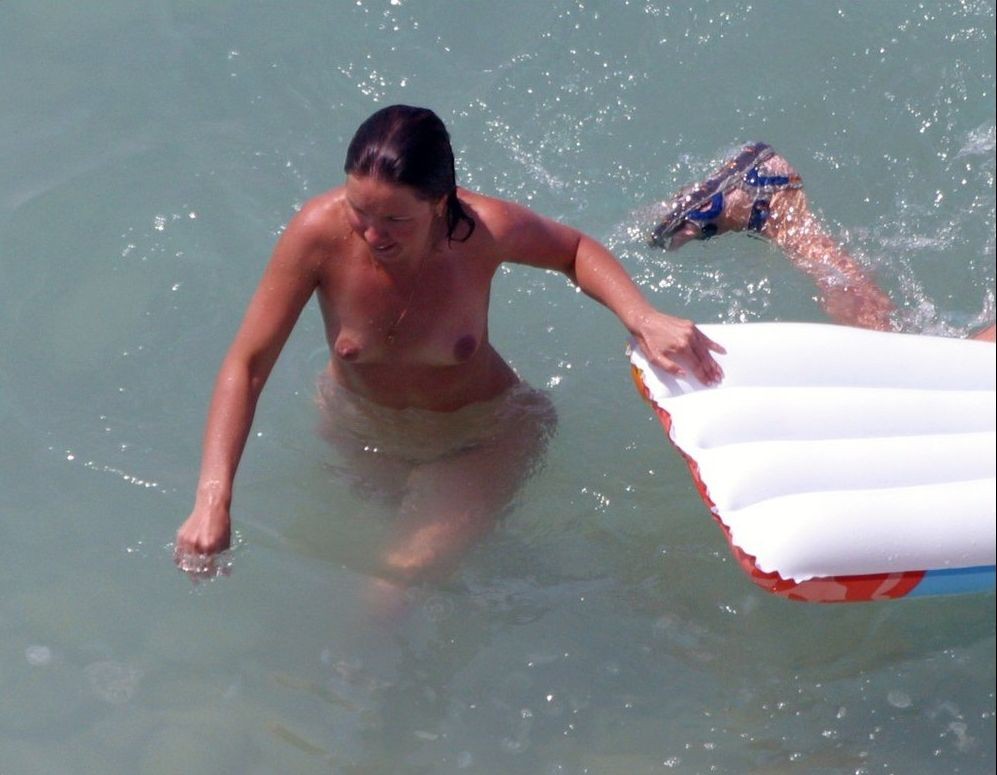 Questi due giovani nudisti giocano a frisbee in acqua
 #72253501