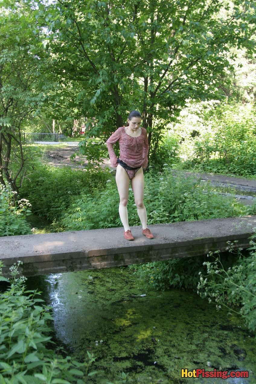 Blushing chick in glasses does a great pee stream from the park bridge #76521268