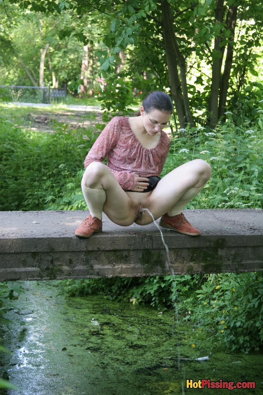 Pulcino arrossendo in occhiali fa un grande flusso di pipì dal ponte del parco
 #76521276